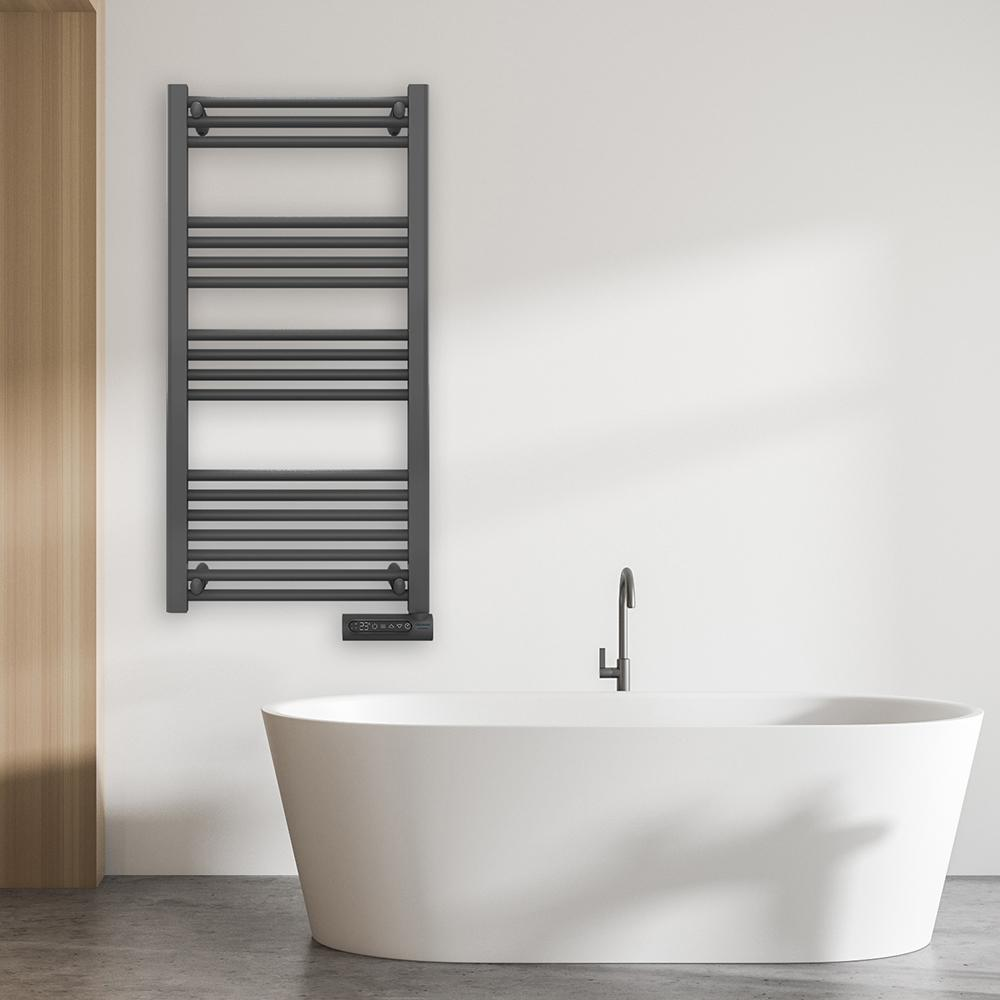 Un baño moderno con bañera blanca, toallero gris oscuro y grifo negro. La pared es blanca y el suelo es de hormigón gris.