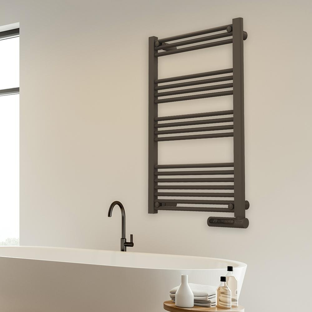 Un baño moderno con un toallero de color gris oscuro en la pared. Una bañera blanca, un grifo negro y una mesa pequeña con objetos delante.