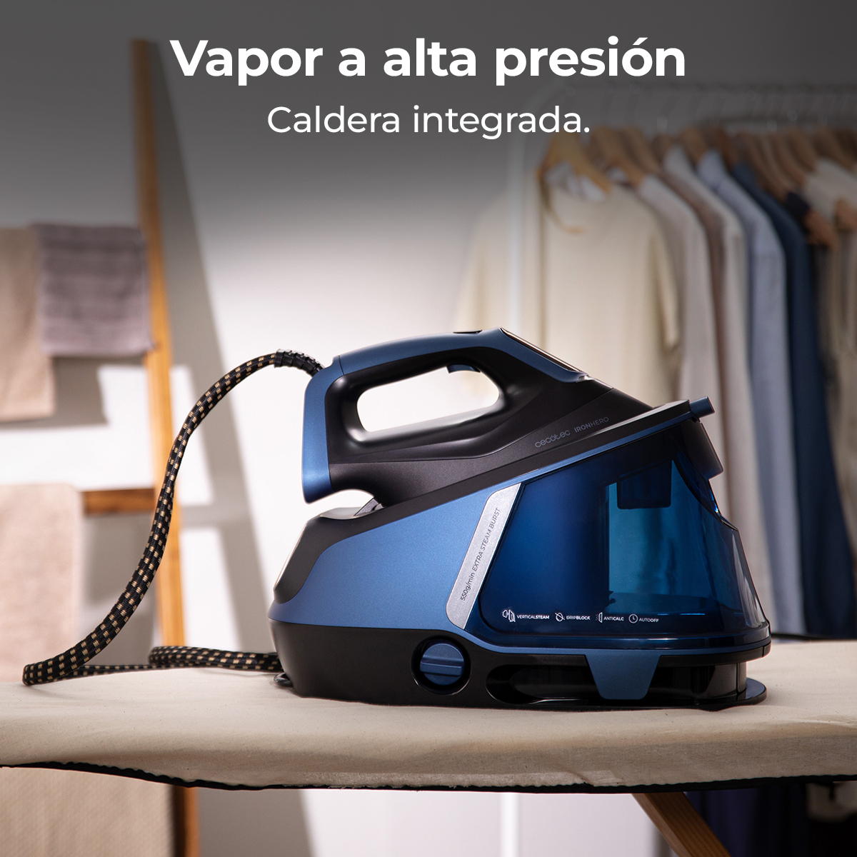 Una plancha azul y negra sobre una tabla de planchar. El fondo muestra ropa colgada en un armario y una escalera de madera.