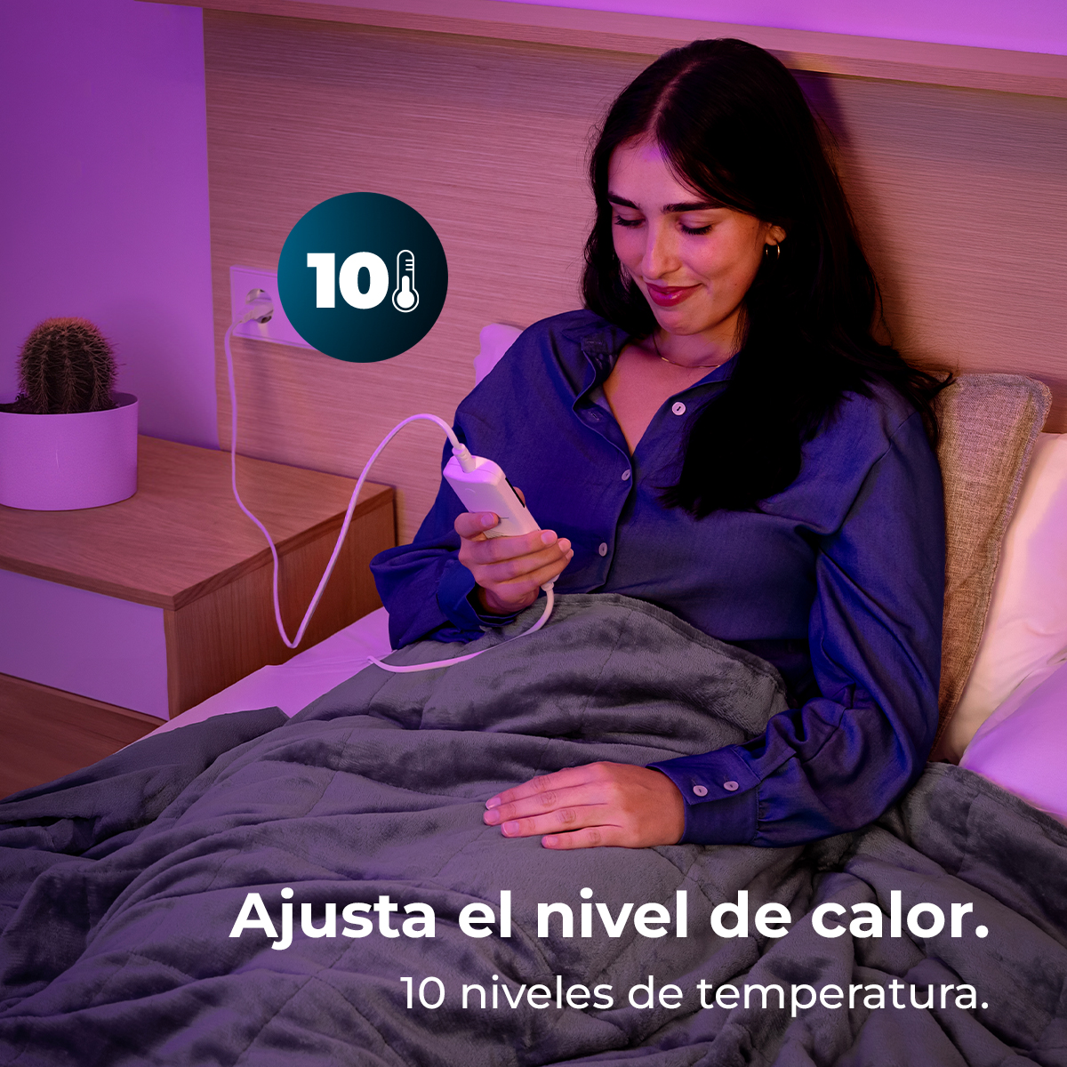 Mujer en la cama ajustando el nivel de calor de una manta. La imagen incluye una manta, un mando y una mesita de noche con un cactus.