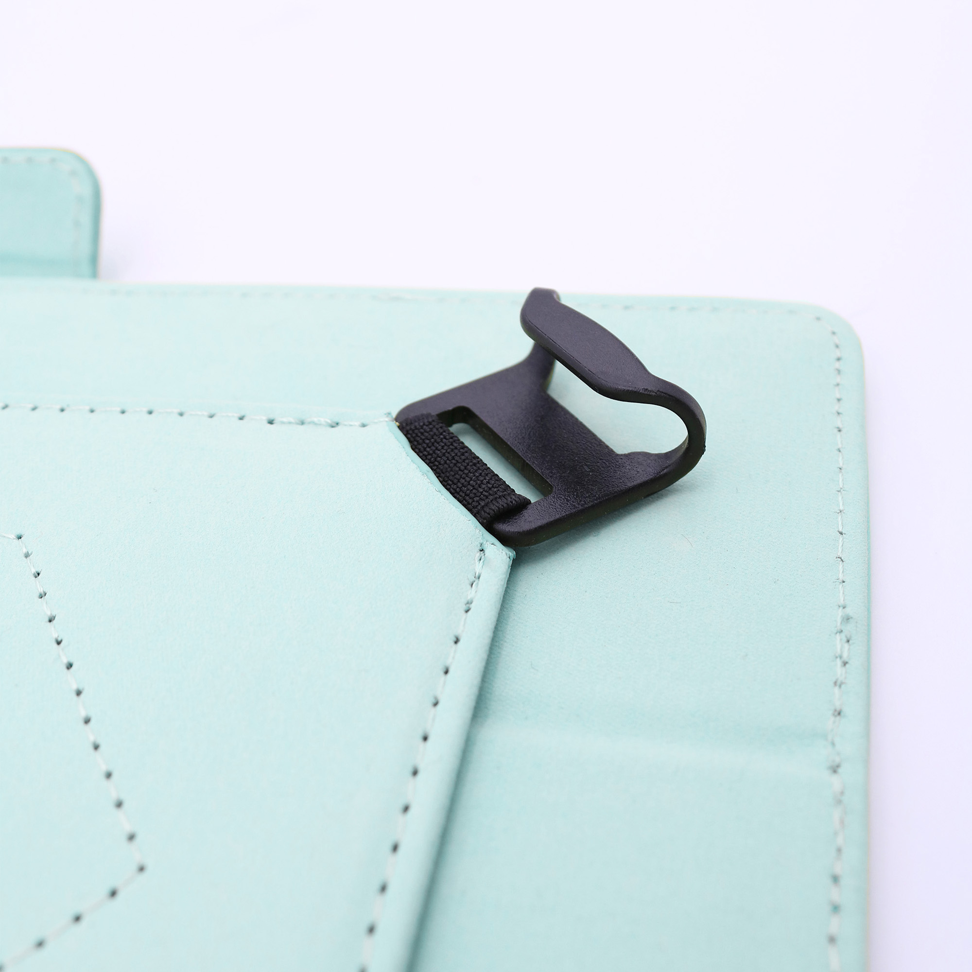 Primer plano de una funda de tableta verde menta con un cierre negro. Fondo blanco. Bordes cosidos visibles.