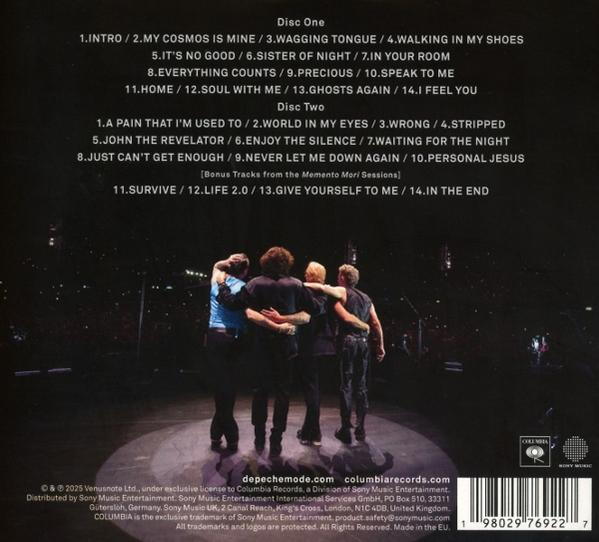 Vier Männer umarmen sich auf der Bühne, Rücken zur Kamera. Album-Titelliste oben. Columbia Records Logo sichtbar.