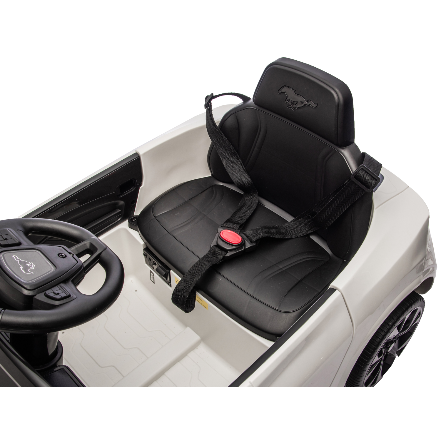 A white toy car with a black seat, steering wheel, and seatbelt. A Mustang logo is on the headrest and steering wheel.