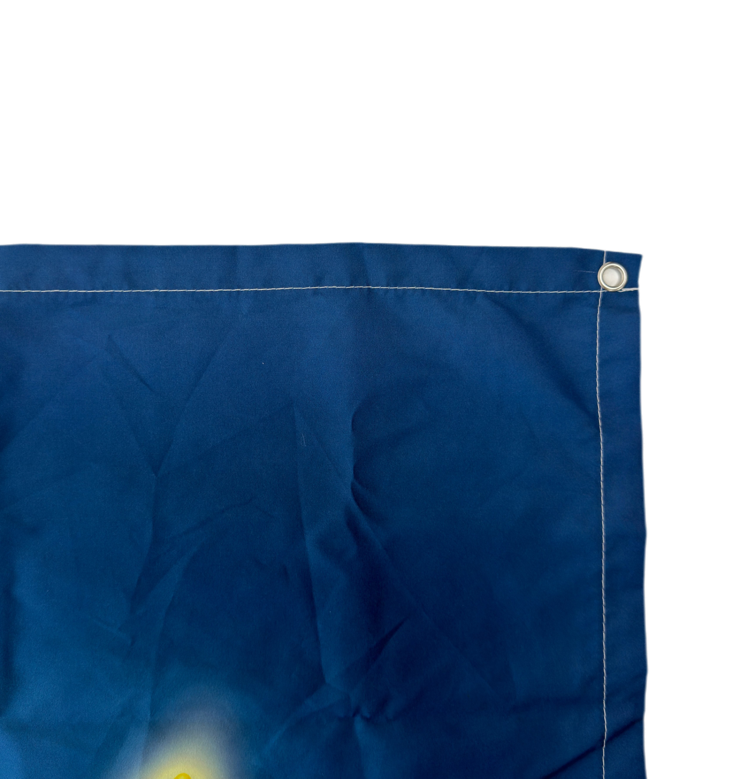 Blaue Flagge Ecke mit Metallöse. Weiße Fadennähte sind sichtbar. Weißer Hintergrund.