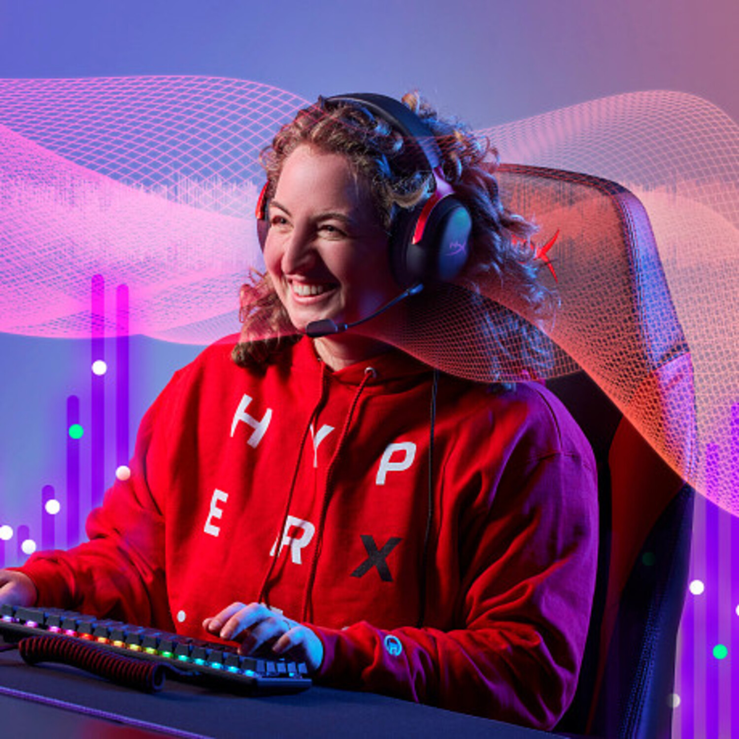 Mujer con auriculares, sudadera roja, sonriendo, jugando con teclado. Fondo con gráficos neón y silla gamer.