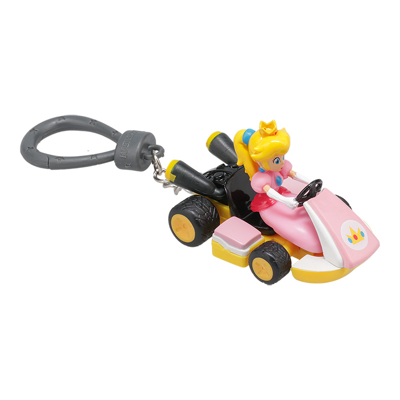 Ein Spielzeug von Prinzessin Peach, die einen rosa-gelben Kartwagen fährt. Der Kartwagen hat schwarze Reifen und einen grauen Schlüsselanhänger.