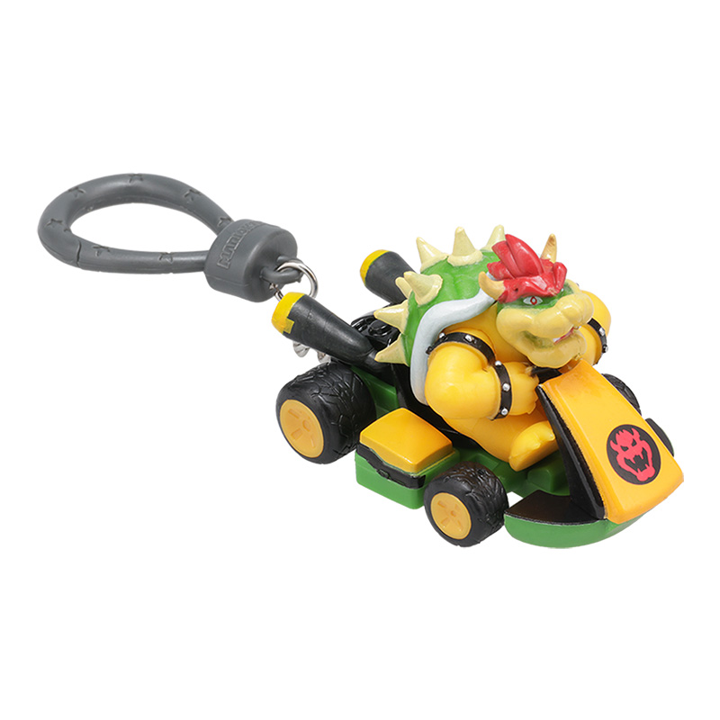 Bowser in einem Kart-Spielzeug. Gelb-grünes Kart mit Bowser-Figur. Inklusive Schlüsselanhänger. Bowser hat rote Haare und einen stacheligen Panzer.