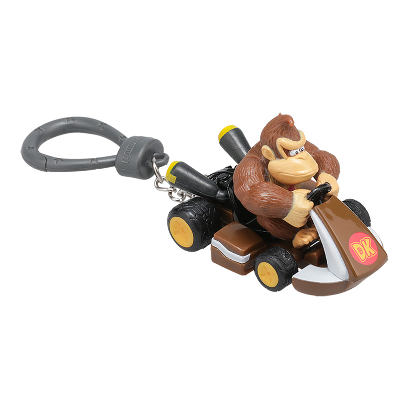 Donkey Kong in einem Kart-Schlüsselanhänger. Das Kart ist braun und die Reifen sind schwarz und gelb. Der Hintergrund ist weiß.