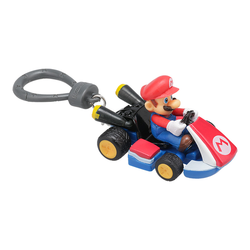 Eine Mario-Figur in einem Kart. Mario trägt einen roten Hut und blaue Latzhosen. Das Kart ist rot, weiß und blau, mit schwarzen Reifen. Ein Schlüsselring ist befestigt.