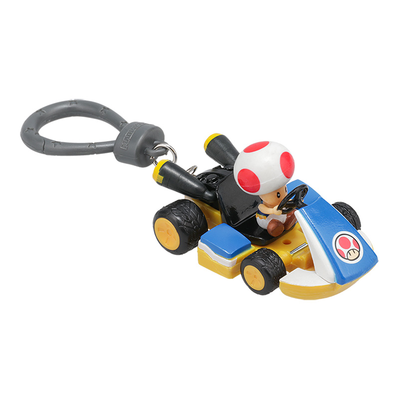 Eine Toad-Figur fährt einen blau-gelben Kart. Der Kart hat schwarze Räder und einen weißen und roten Pilz auf Toads Kopf.