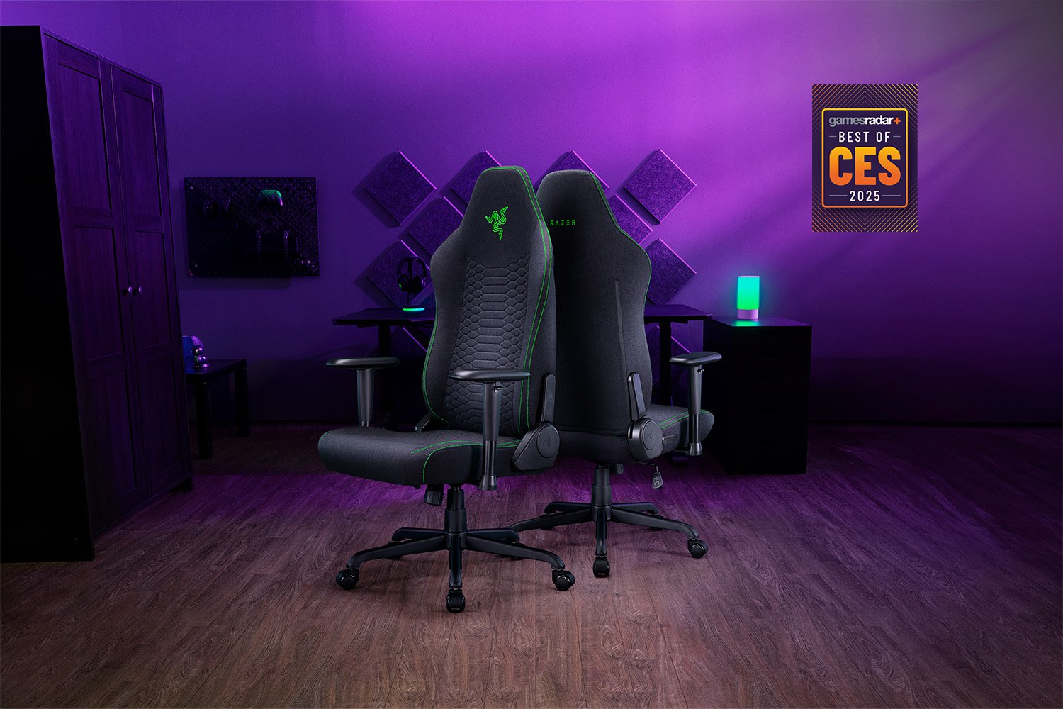 Két fekete Razer gamer szék egy lila szobában. A falon egy CES 2025 díj. Sötét fa padló és szekrény látható.