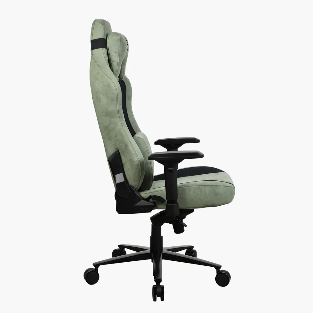 Zöld-fekete gamer szék profilból. Magas háttámla, karfák, görgős talp, fehér háttér előtt.