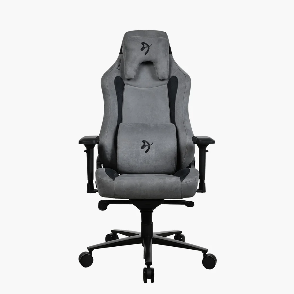 Szürke gamer szék fekete díszítéssel. Fejtámlával, deréktámasszal, karfákkal és ötkerekes talppal. A szék fehér háttér előtt van.