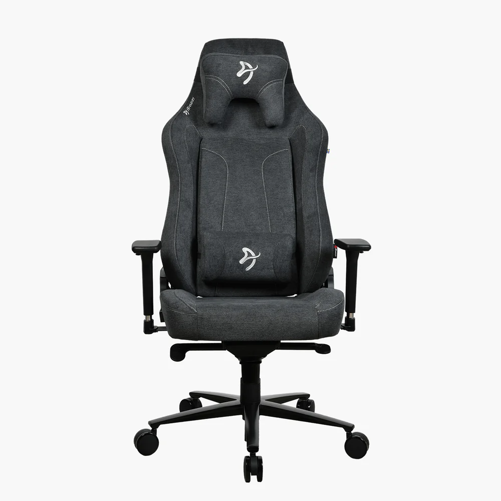 Egy szürke gamer szék fehér varrással és logókkal. Fejtámlával, háttámlával, kartámaszokkal és egy ötágú csillag talppal rendelkezik.