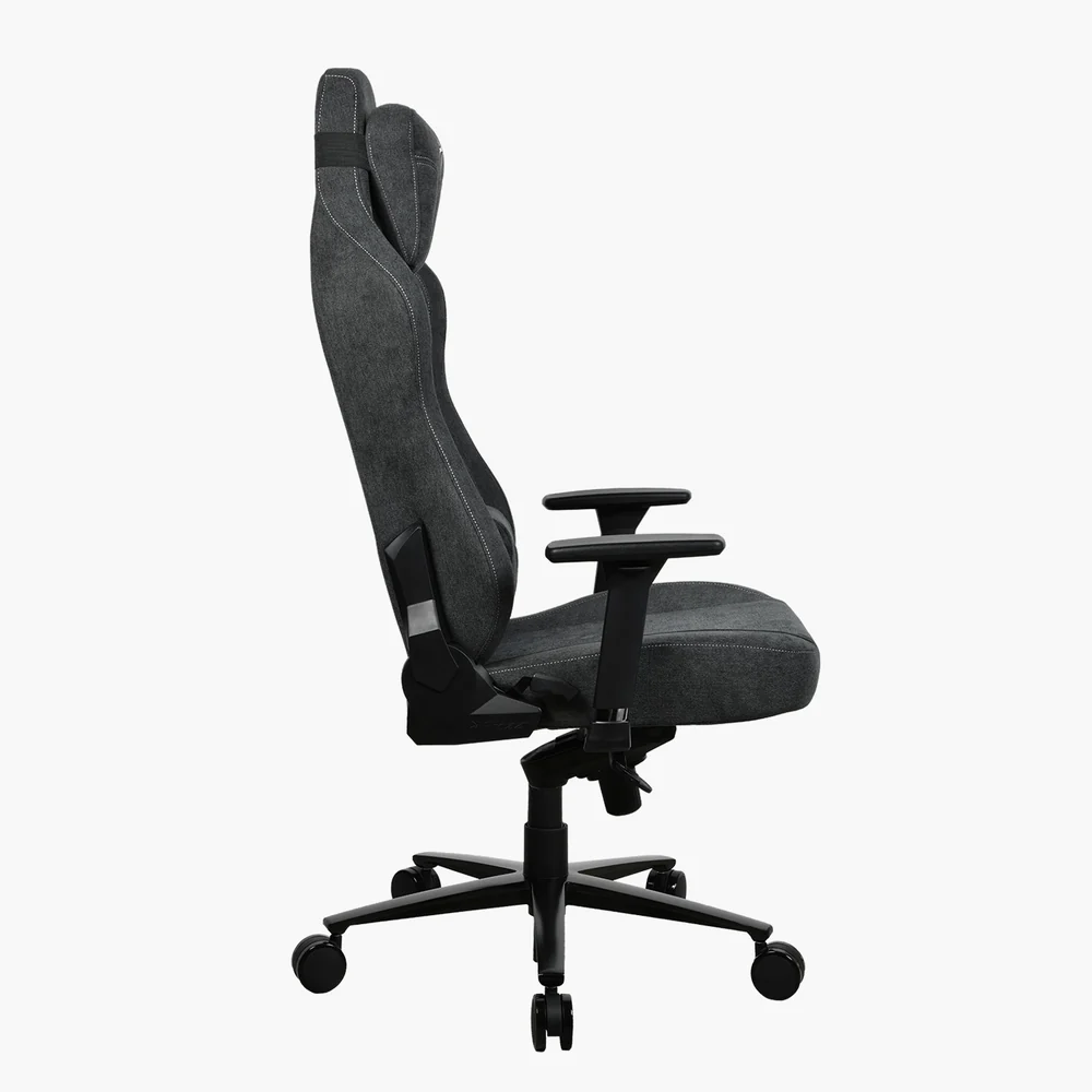 Egy szürke és fekete ergonomikus gamer szék. Magas háttámlával, karfákkal és ötkerekű talppal rendelkezik. A szék fehér háttér előtt van.