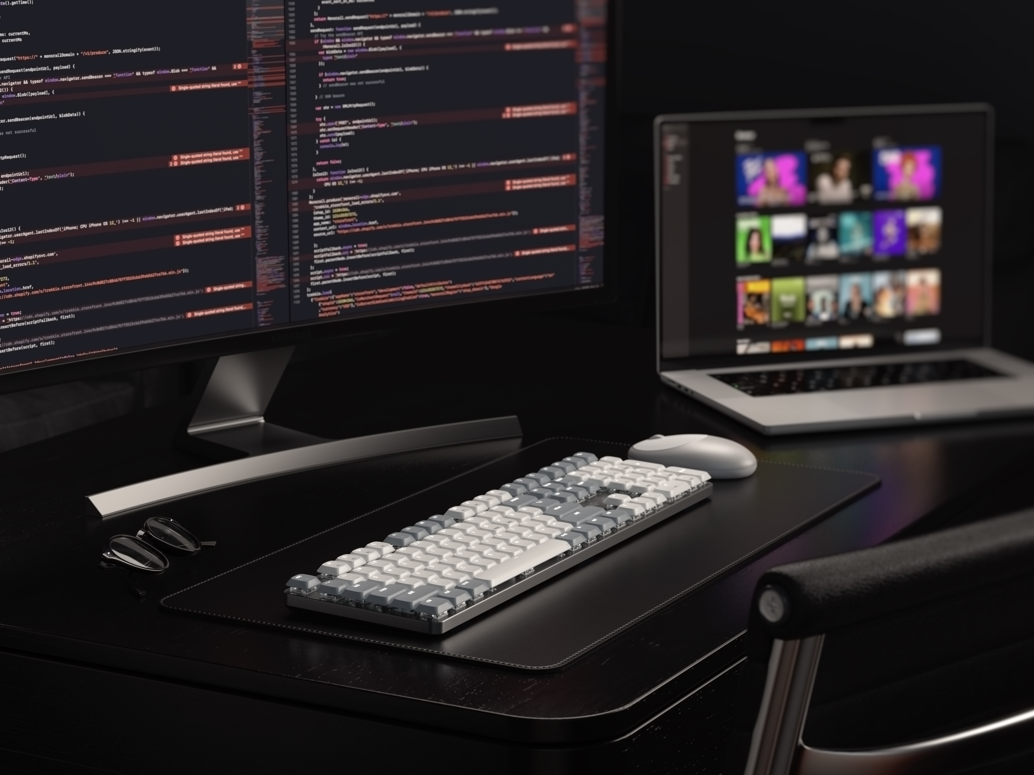 Schreibtisch mit Monitor, Tastatur, Maus und Laptop, der einen Streaming-Dienst zeigt.