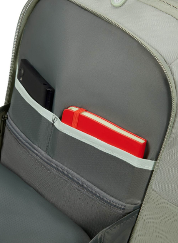 Wewnątrz plecaka czarny telefon i czerwony notatnik w oddzielnych kieszeniach. Plecak jest szary.