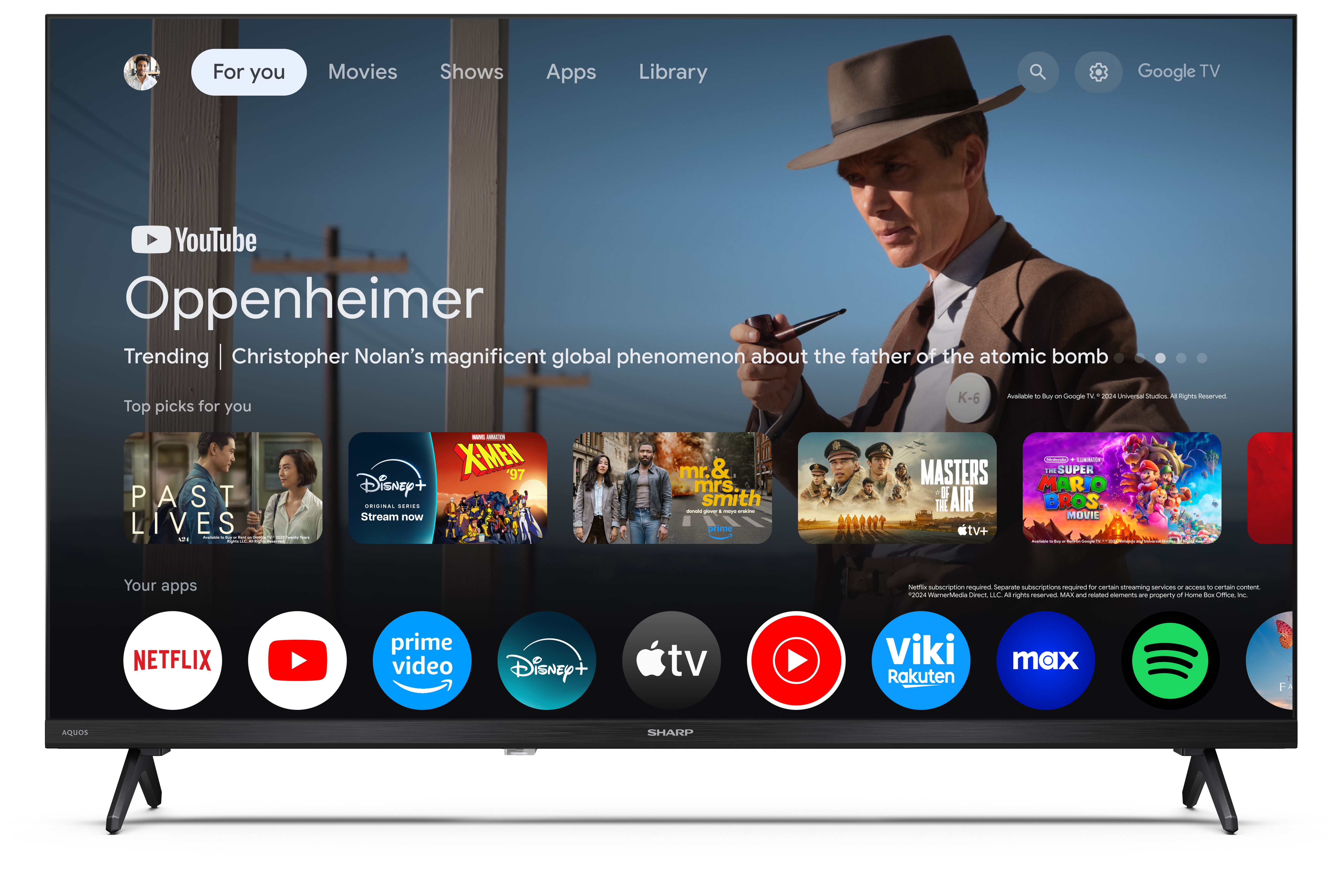 A TV képernyője a Google TV felületét mutatja. Oppenheimer filmet és Netflix, Disney+ ikonokat jelenít meg.