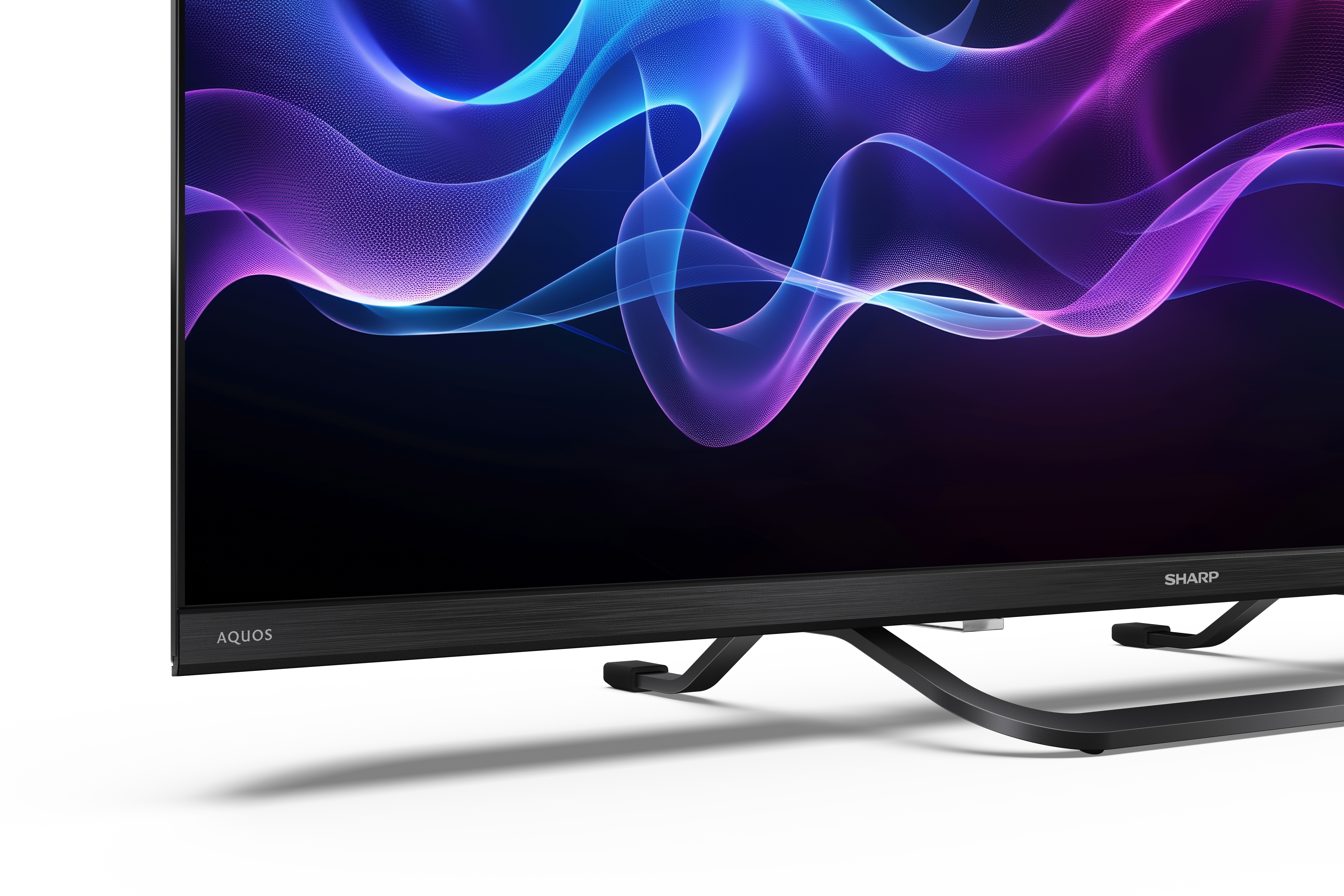A Sharp Aquos TV kék és lila vonalakat jelenít meg. Fekete állványa és fehér háttere van.