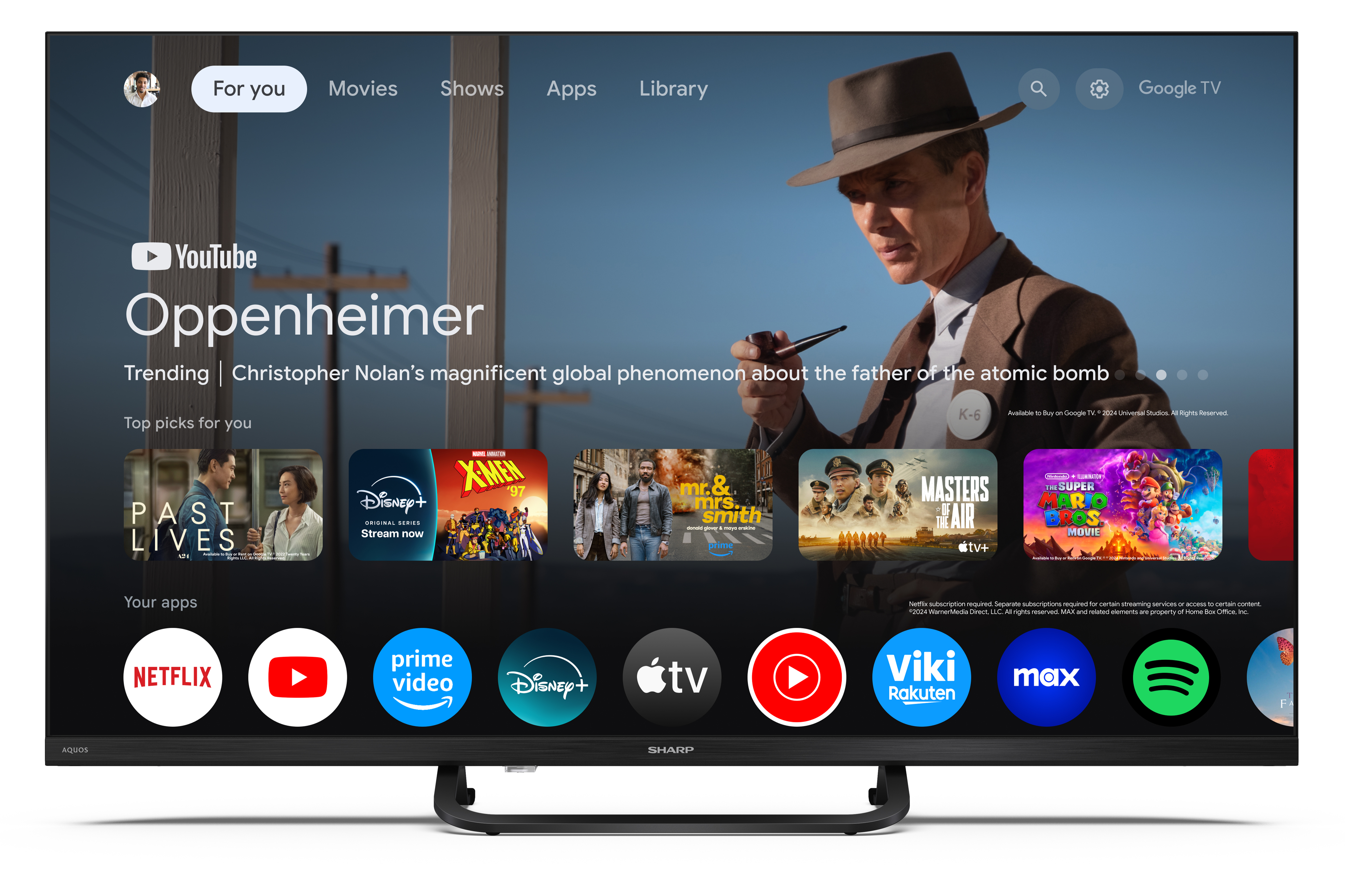 A TV képernyője a Google TV felületét mutatja. Az Oppenheimer filmet mutatja be. Olyan alkalmazások láthatók, mint a Netflix, a YouTube és a Disney+.
