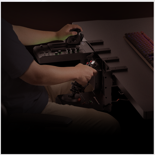 Bir kişi, bir joystick ve kontrol paneli ile bir uçuş simülatörü kurulumu kullanıyor. Eller kontrollerde.