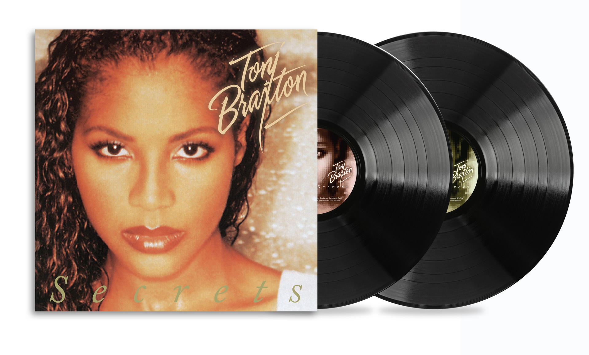 Albumcover von Toni Braxton, mit ihrem Gesicht im Vordergrund. Zwei Schallplatten daneben. Albumtitel: Secrets.