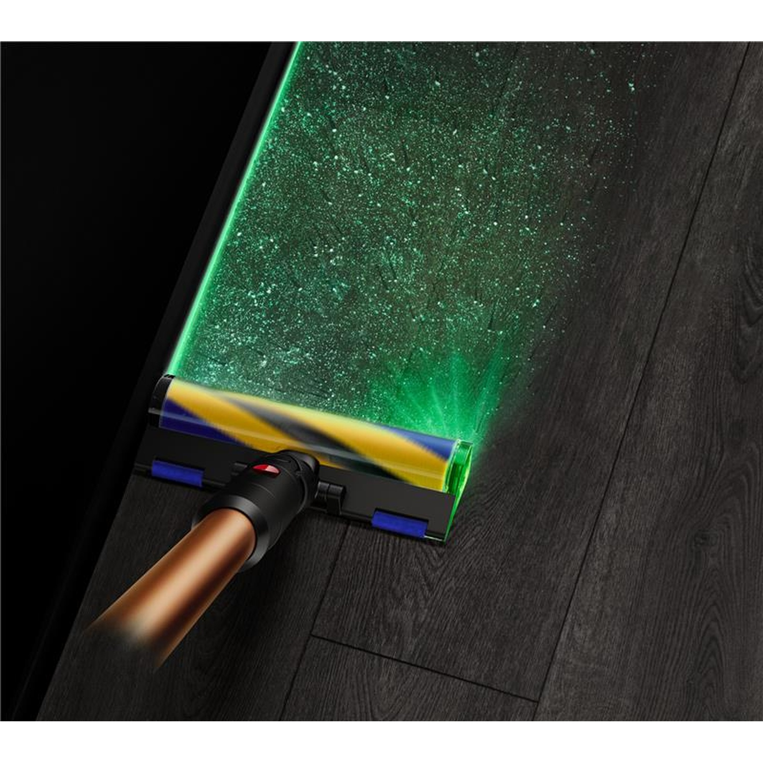 Een stofzuiger met een groene laser die stof op een donkere houten vloer onthult. De stofzuiger heeft gele en blauwe onderdelen.