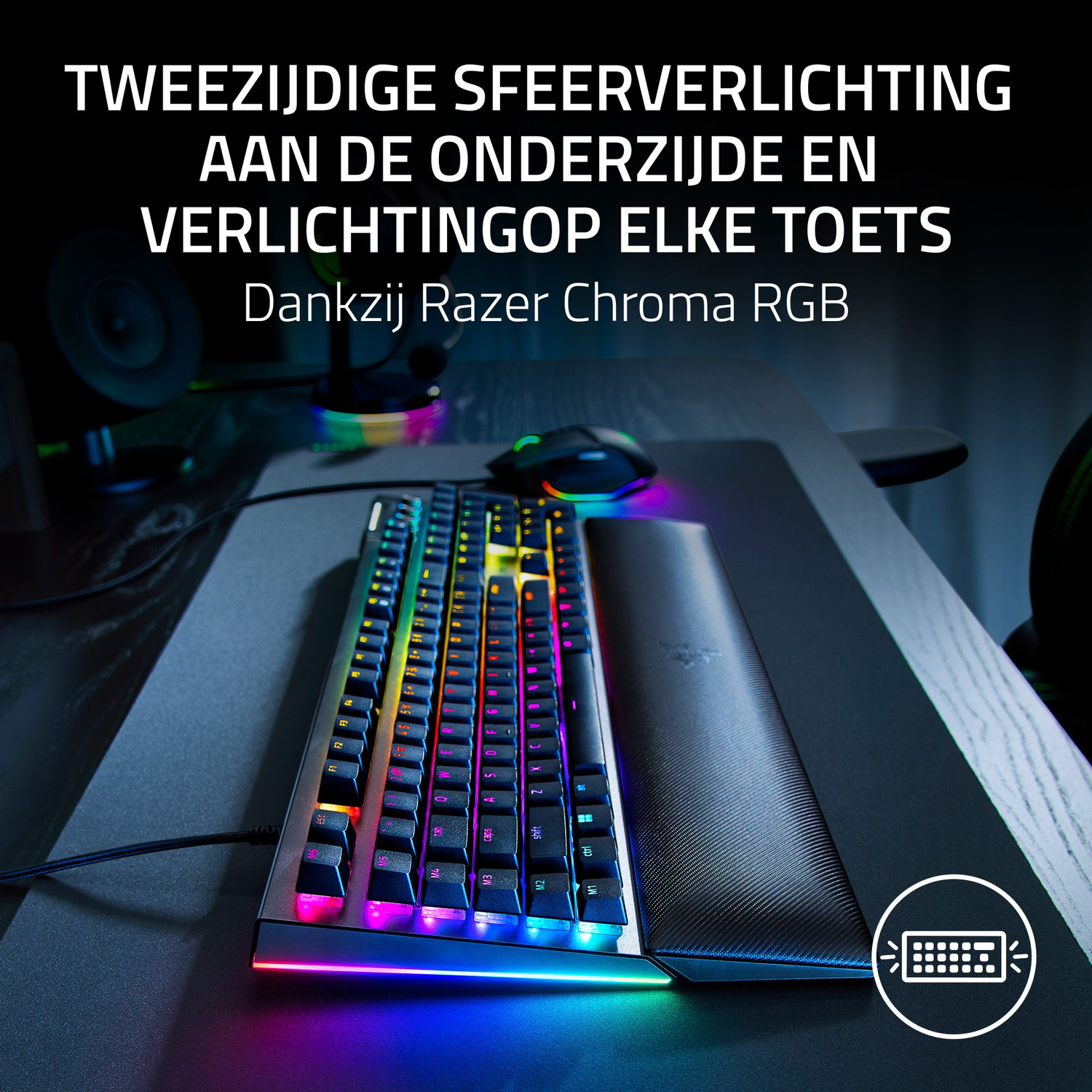 Een verlicht toetsenbord met regenboogkleurige lichten op een bureau. Er zijn ook een muis en een polssteun aanwezig.