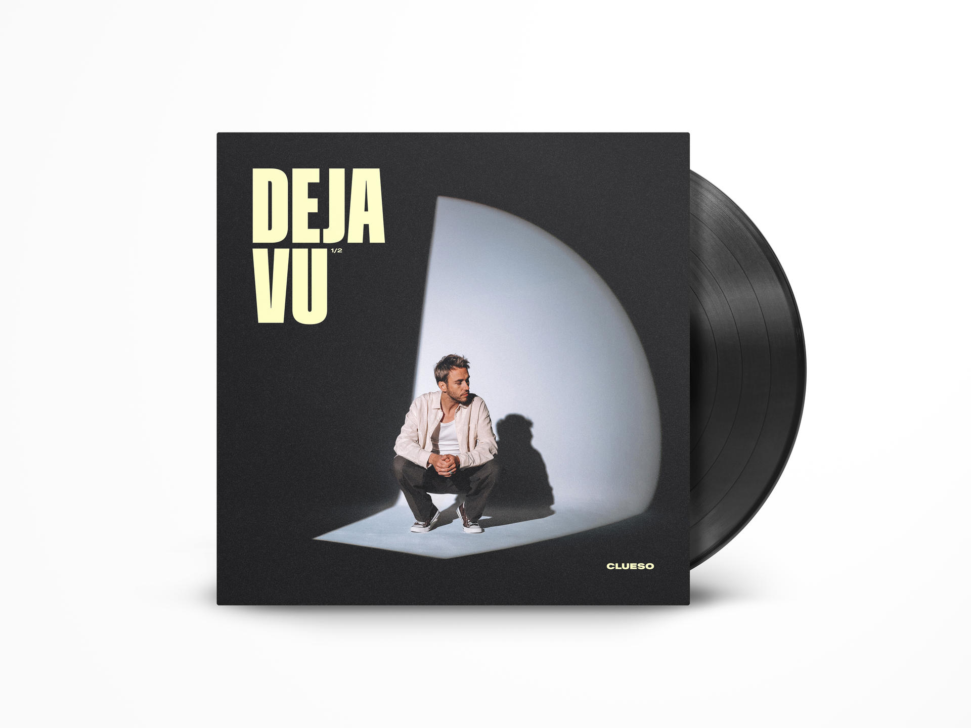 Albumcover 'Deja Vu' mit einem Mann im Rampenlicht. Vinyl rechts. Schwarzes Cover mit weißem Text und Künstlernamen.