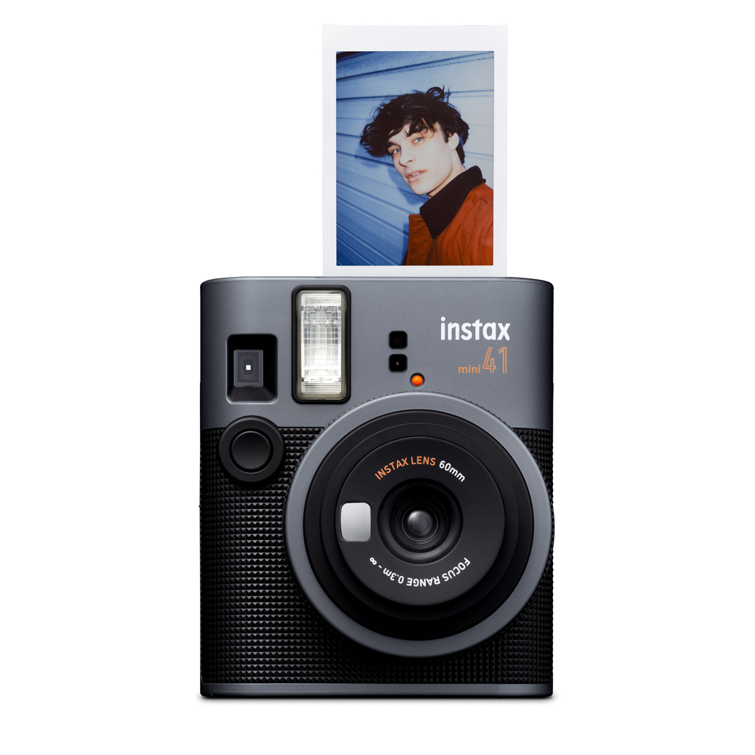 Gri Instax Mini 41 fotoğraf makinesi ve bir kişinin fotoğrafı. Makinede bir lens ve flaş var. Fotoğrafta bir kişi görülüyor.