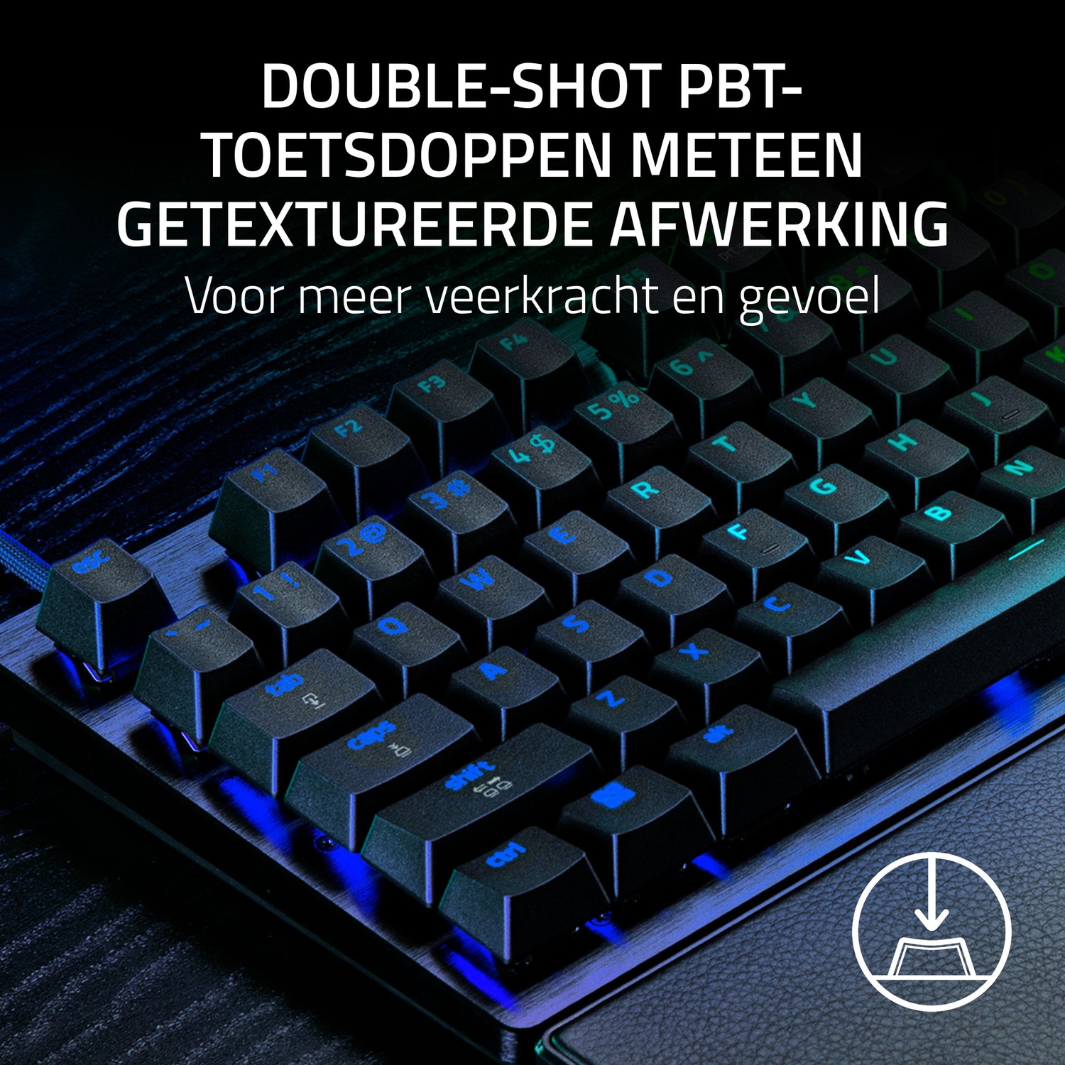 Close-up of a black keyboard with blue illuminated keys. Text on top says 'DOUBLE-SHOT PBT-TOETSDOPPEN'. The keyboard is on a desk.
