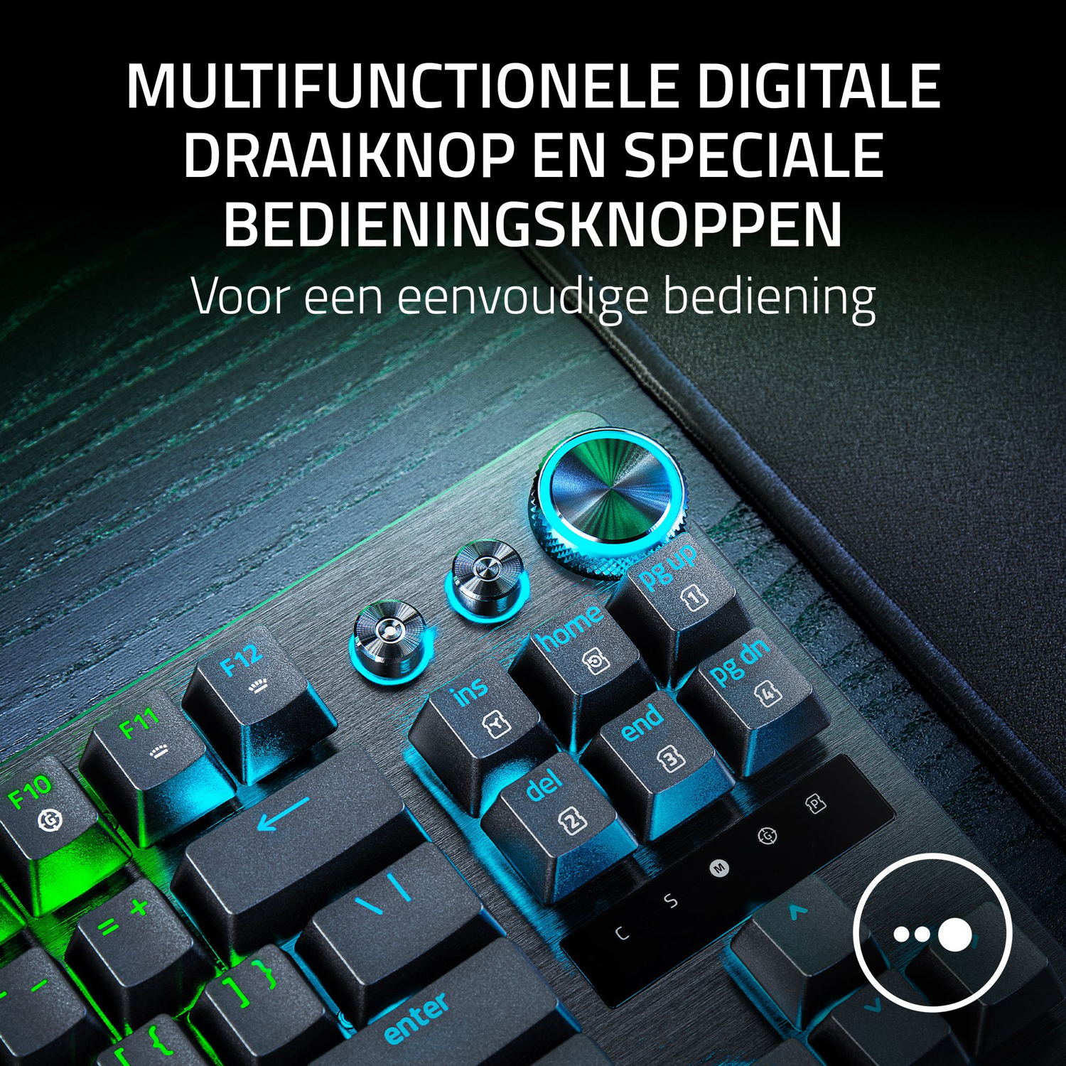Close-up of a black keyboard with illuminated blue and green keys, including function keys, and a large rotary dial with a blue glow.