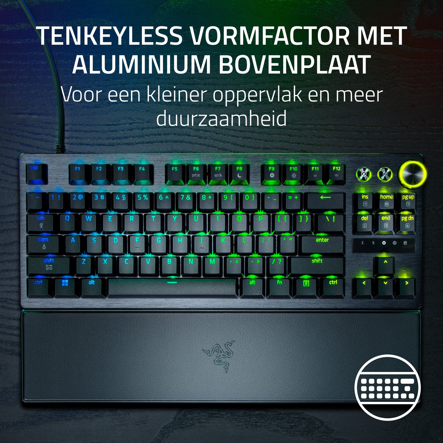 A black keyboard with green and blue illuminated keys and a wrist rest.