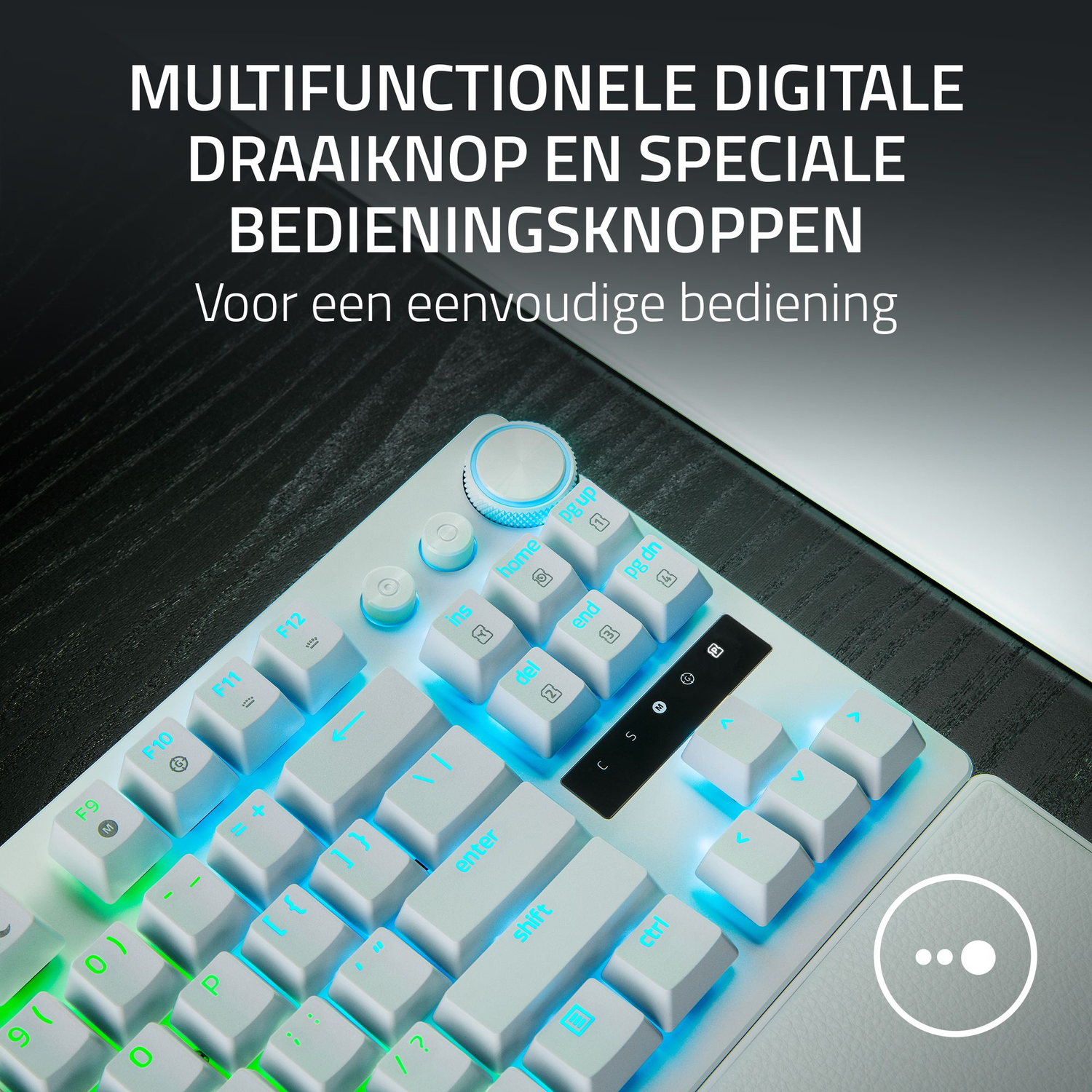A white keyboard with blue backlit keys and a control dial. Text in Dutch at the top. The keyboard is on a dark surface.