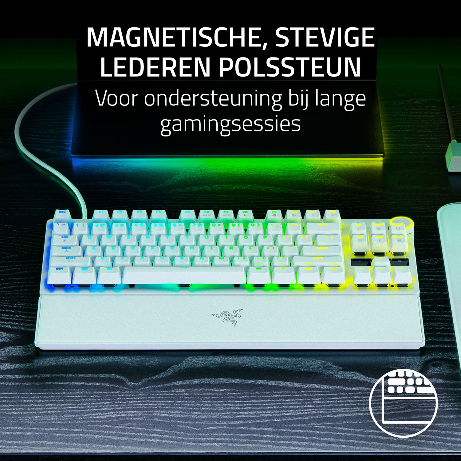 A white keyboard with rainbow lights, resting on a dark wood desk. The keyboard has a wrist rest, and a mouse is on the right.