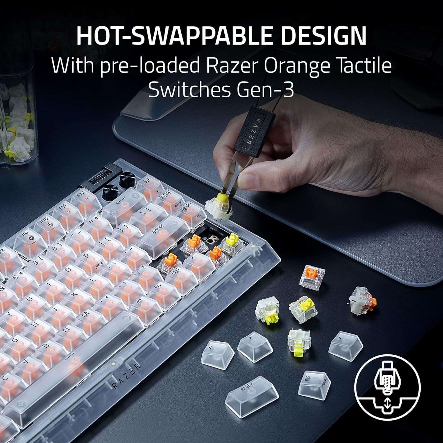 A keyboard with clear keycaps and orange switches is shown. A hand uses a tool to remove a switch. Extra switches and keycaps are nearby.