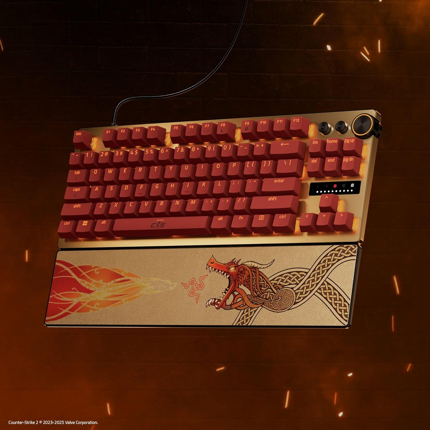 A gaming keyboard with red keys, gold frame, and a dragon design on the wrist rest.