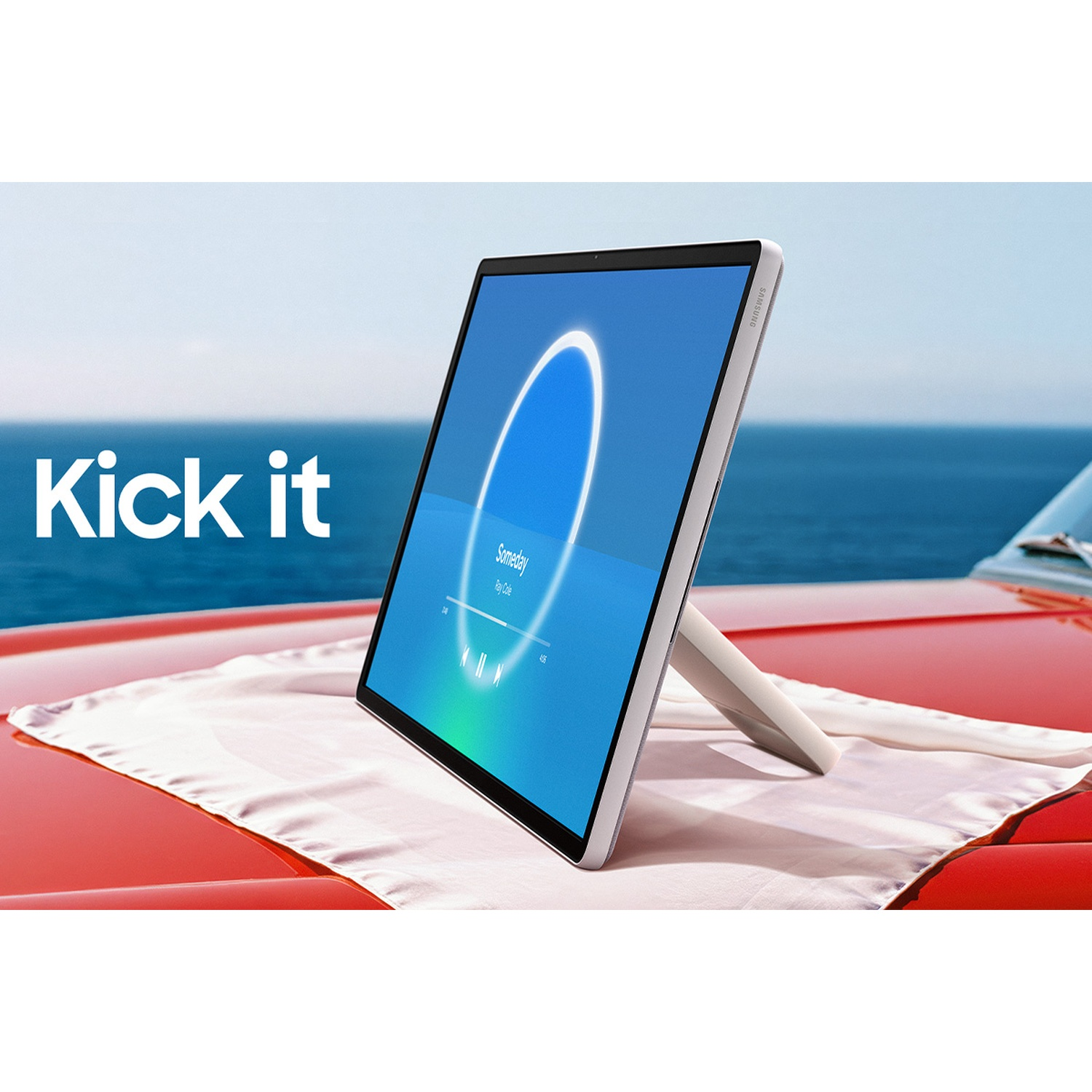 Tablette sur une voiture rouge avec l'océan en arrière-plan. La tablette affiche une interface musicale. Le texte 'Kick it' est visible.