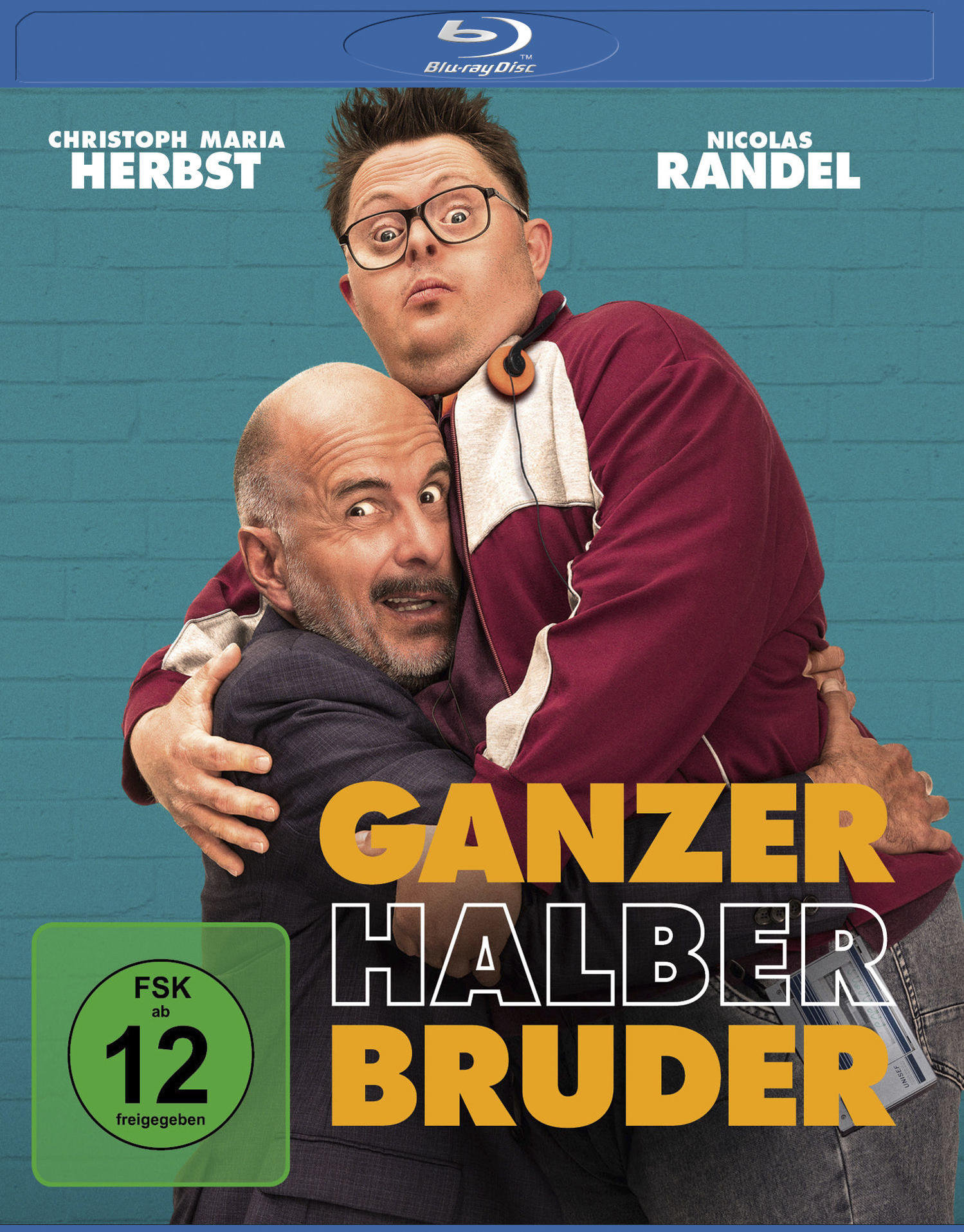 DVD-Cover. Zwei Männer umarmen sich. Text: Ganzer Halber Bruder. Namen der Schauspieler: Christoph Maria Herbst, Nicolas Randel. Blu-ray Disc Logo.