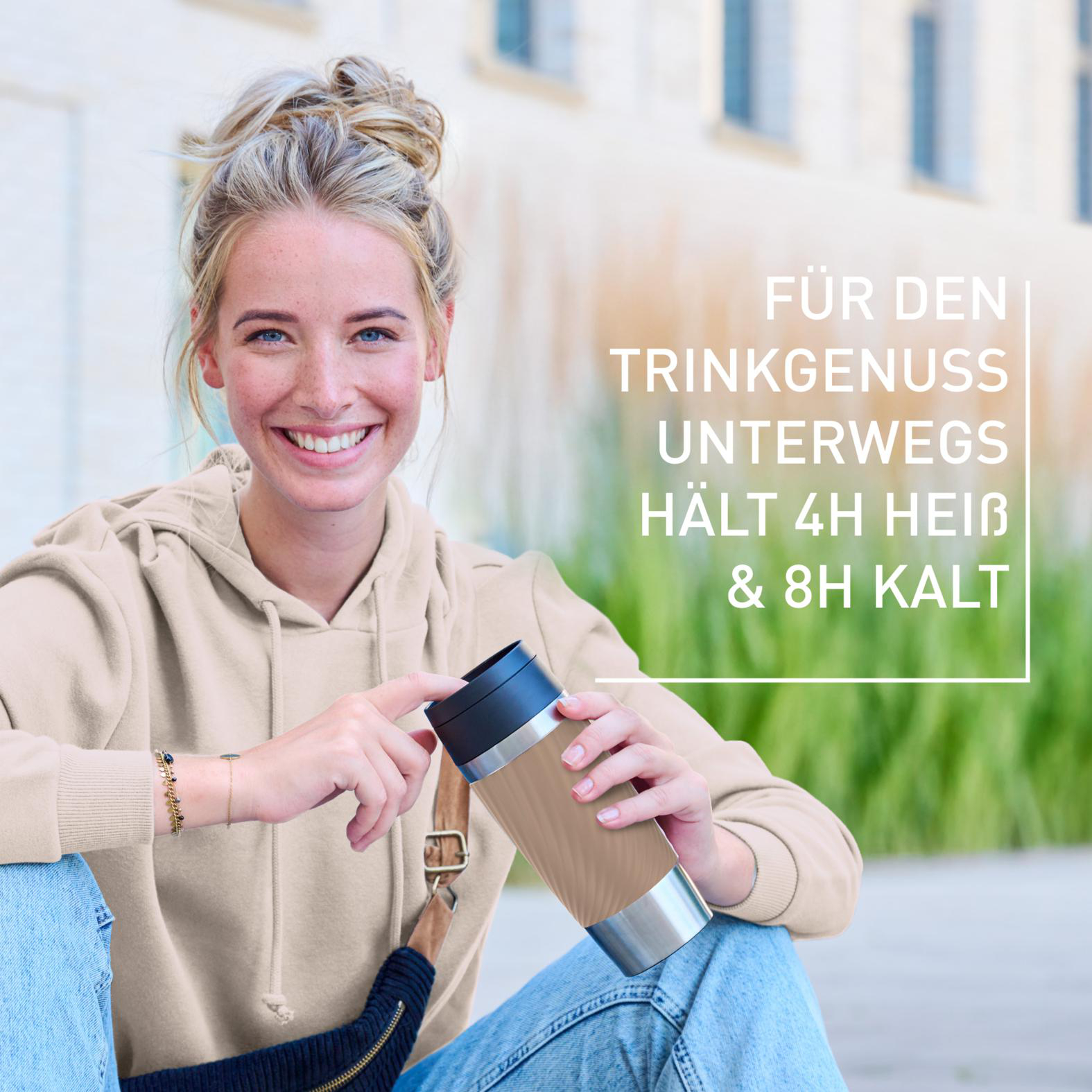 Junge Frau lächelt, hält einen Reisebecher. Text: Für Trinkgenuss unterwegs, hält 4h heiß & 8h kalt.