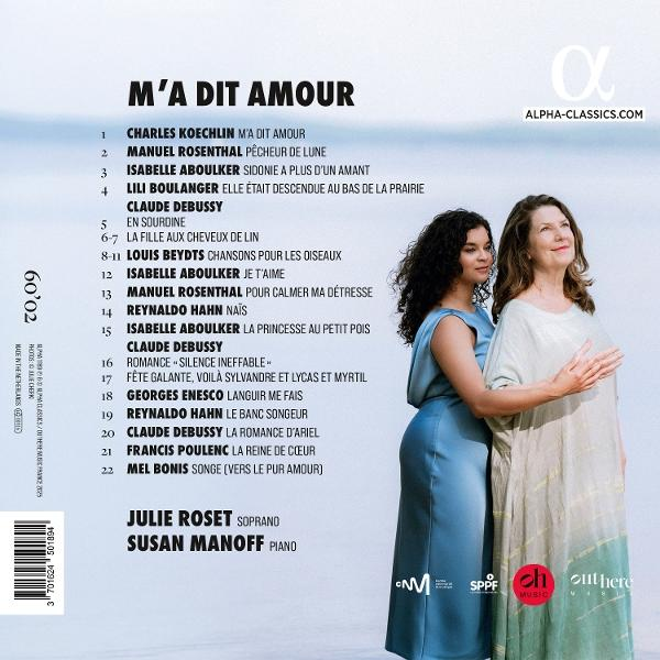 Zwei Frauen, eine in Blau, eine in Beige, stehen neben einem Text, der Musikkompositionen und Namen auflistet.