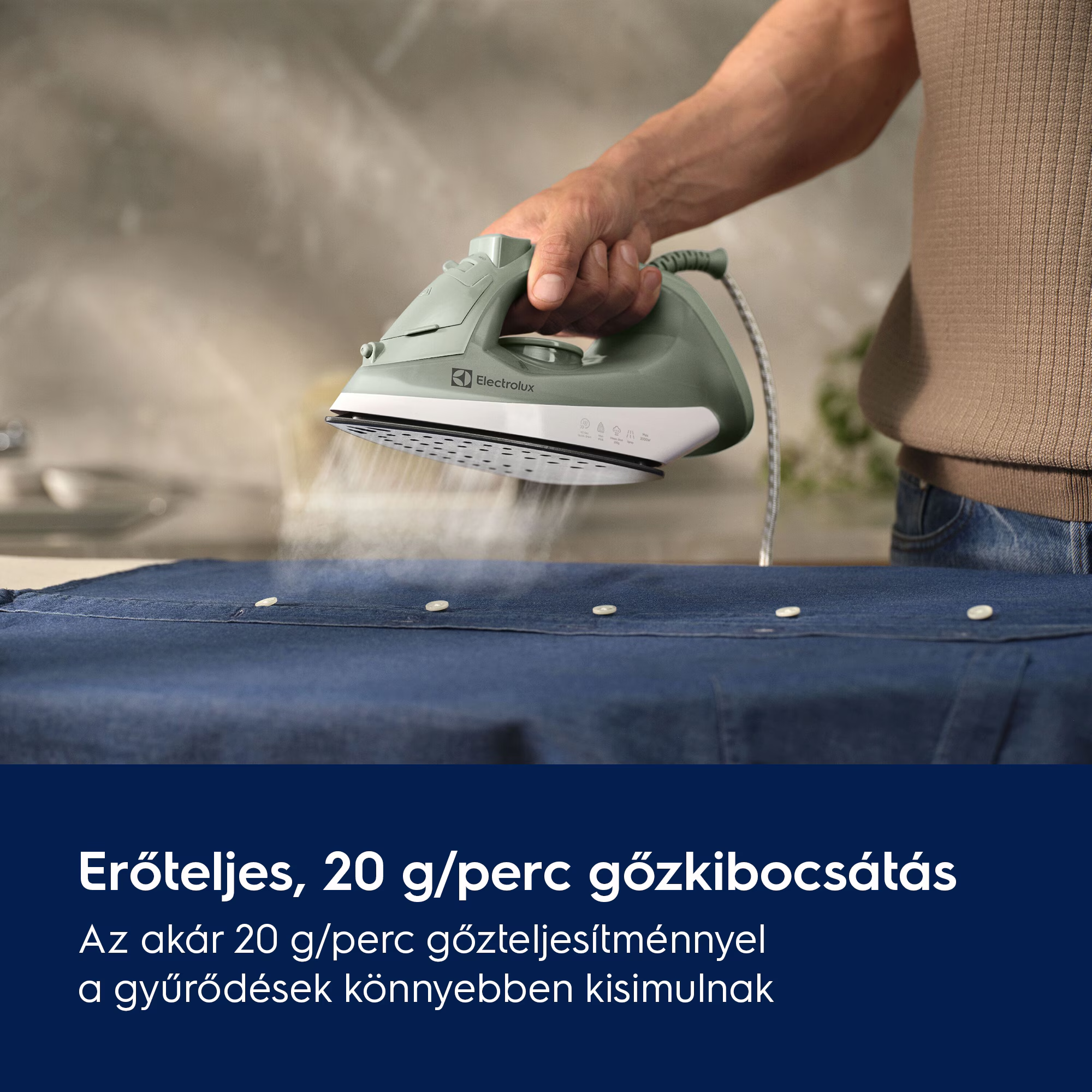 Egy személy kék inget vasal gőzölős vasalóval. A vasaló zöld és fehér. Szöveg alul.