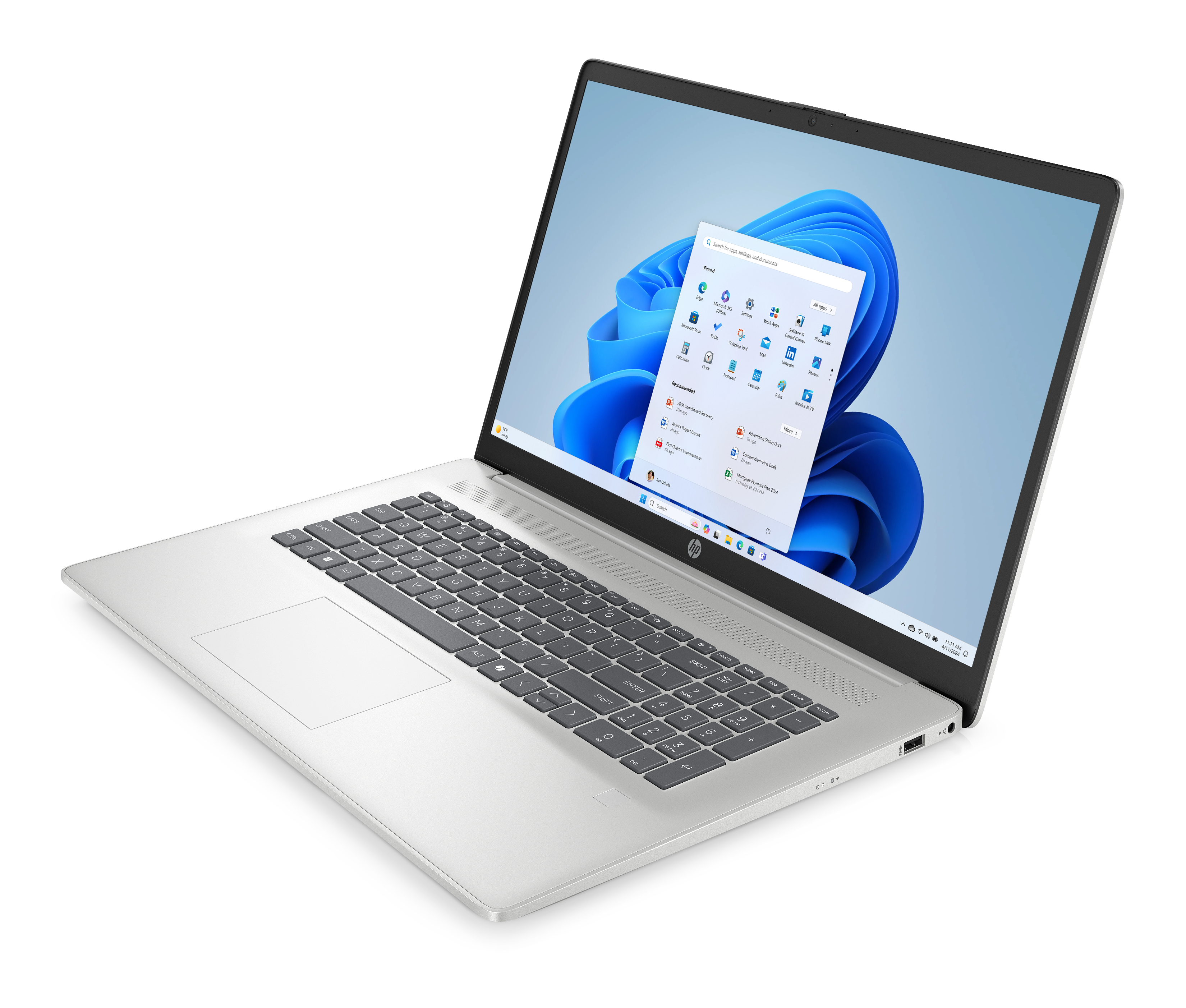 Srebrny laptop na czarnej powierzchni. Ekran pokazuje interfejs Windows 11 z ikonami aplikacji.