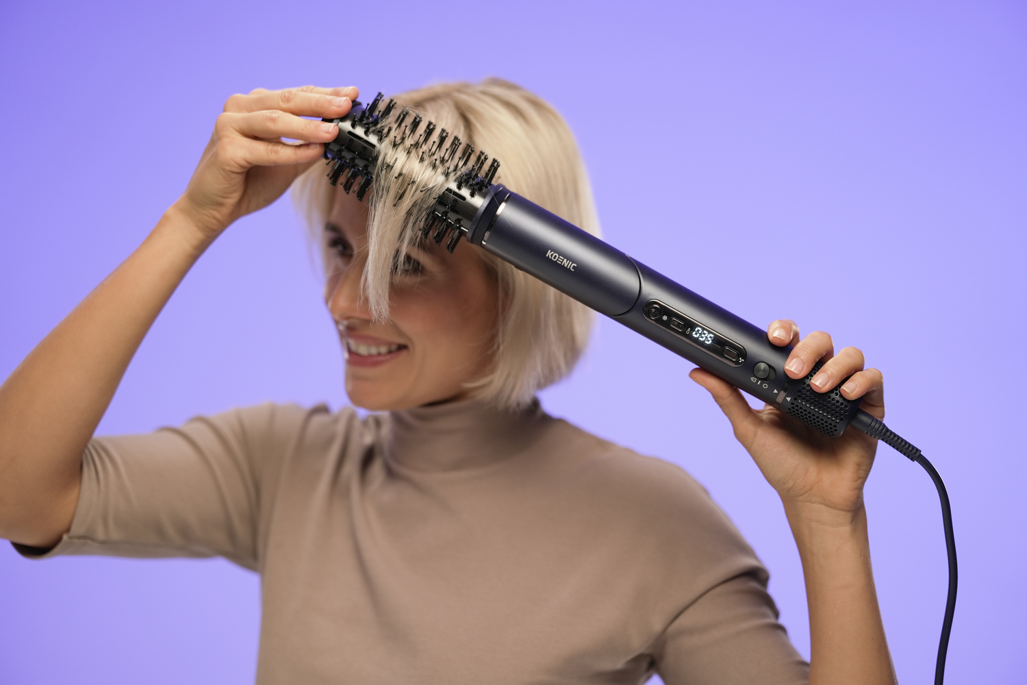 Una mujer peina su cabello rubio con un cepillo negro. Ella sonríe. El fondo es un degradado púrpura.