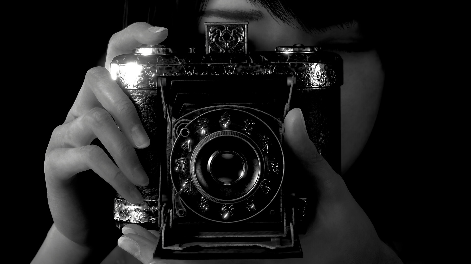Una persona tiene in mano una fotocamera vintage, inquadrata dalle sue mani. La fotocamera è ornata. Lo sfondo è nero.