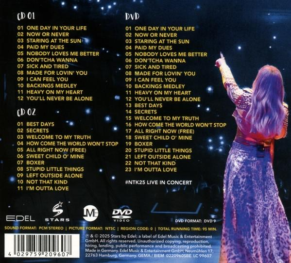 CD- und DVD-Titellisten mit einer Frau in Konzertkleidung auf der Bühne, die nach oben zeigt. Dunkler Hintergrund.