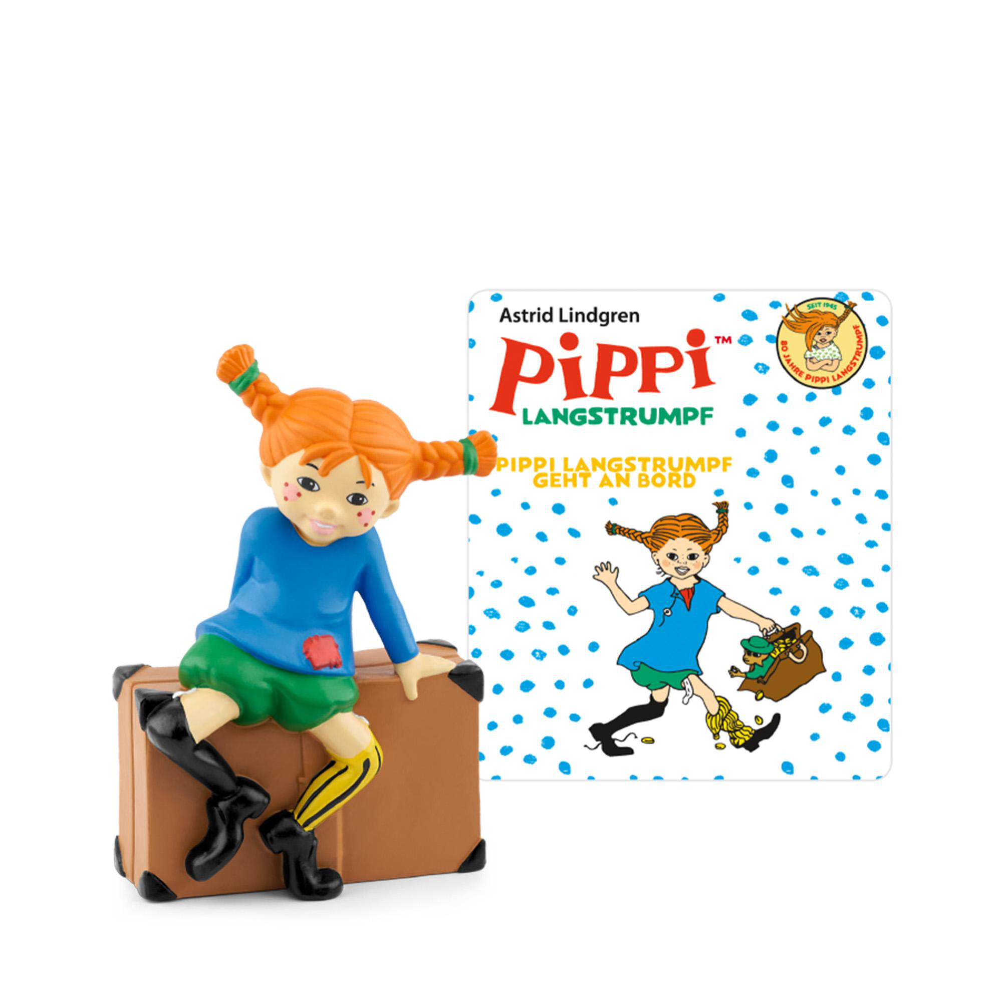 Pippi Langstrumpf-Figur auf einem Koffer, mit einem Buch, das Pippi mit einer Tasche voller Goldmünzen und einem Kind zeigt.