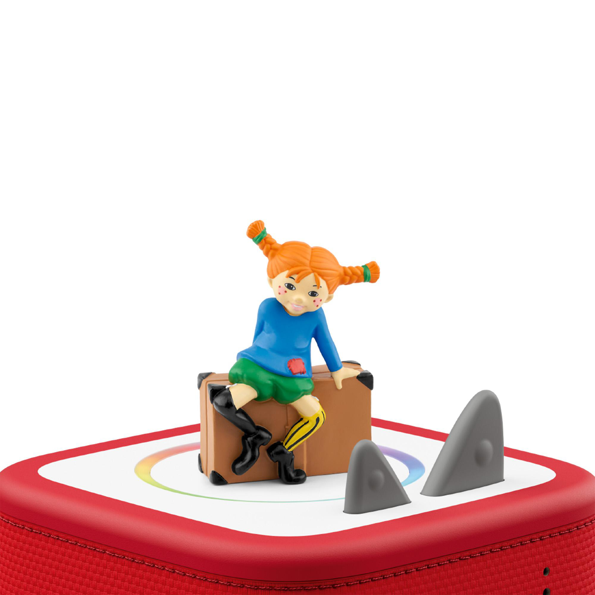 Eine Figur von Pippi Langstrumpf sitzt auf einem Koffer auf einem roten Lautsprecher. Graue Haifischflossen sind vorhanden.
