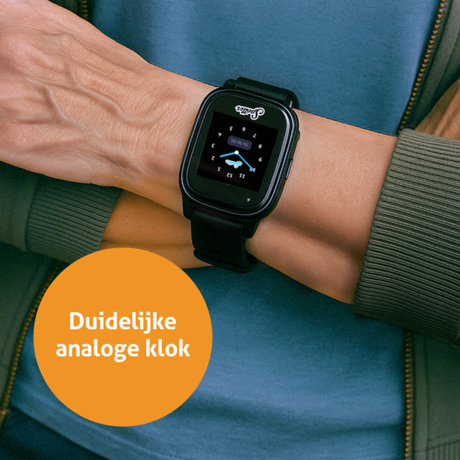 Poignet avec une smartwatch noire affichant une horloge analogique. La montre est sur une chemise bleue avec une veste verte.