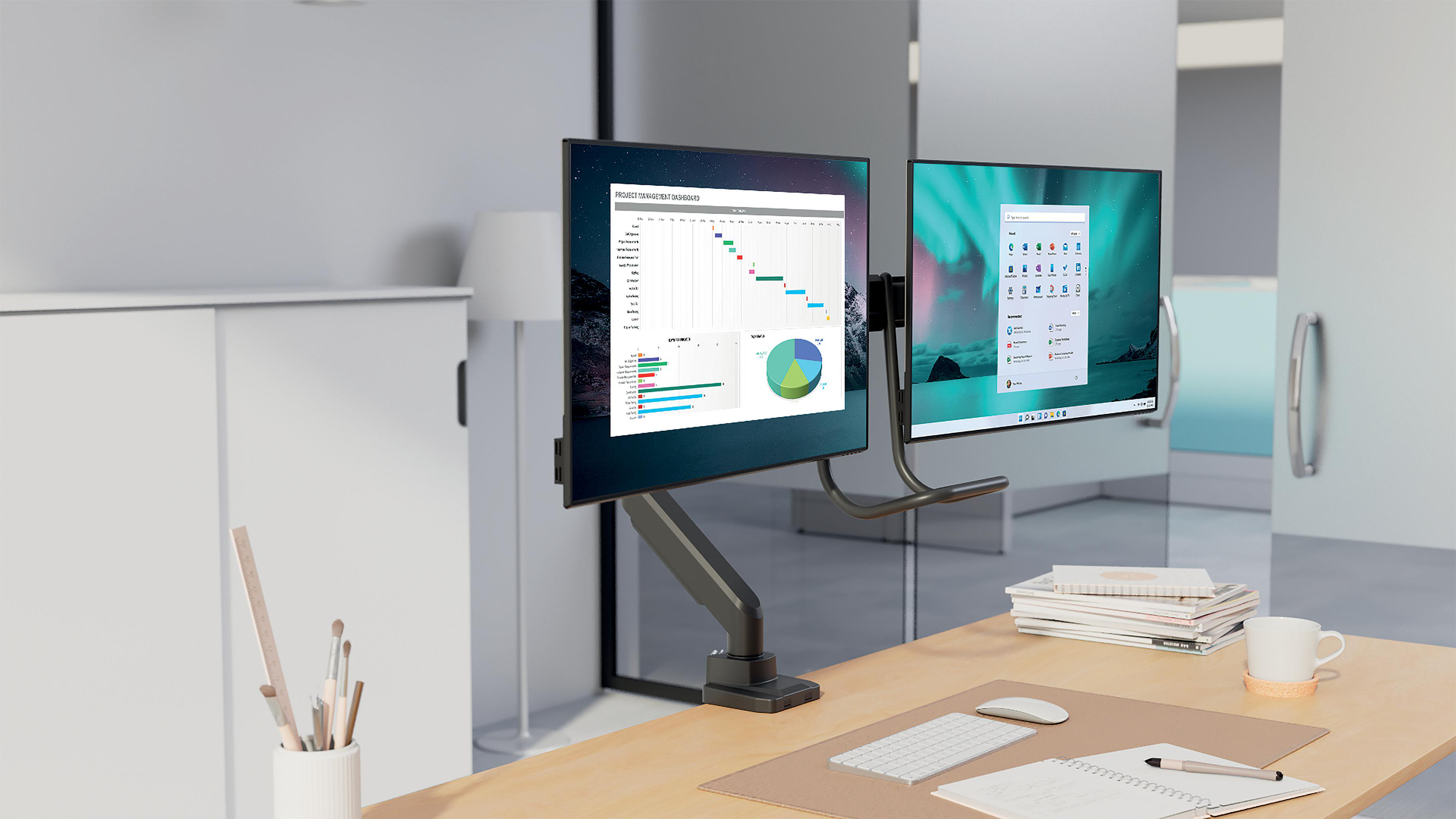 Zwei Monitore zeigen Projektinfos und Windows-Oberfläche. Schreibtisch mit Tastatur, Maus, Notizblock und Kaffeetasse. Weißer Schrank im Hintergrund.